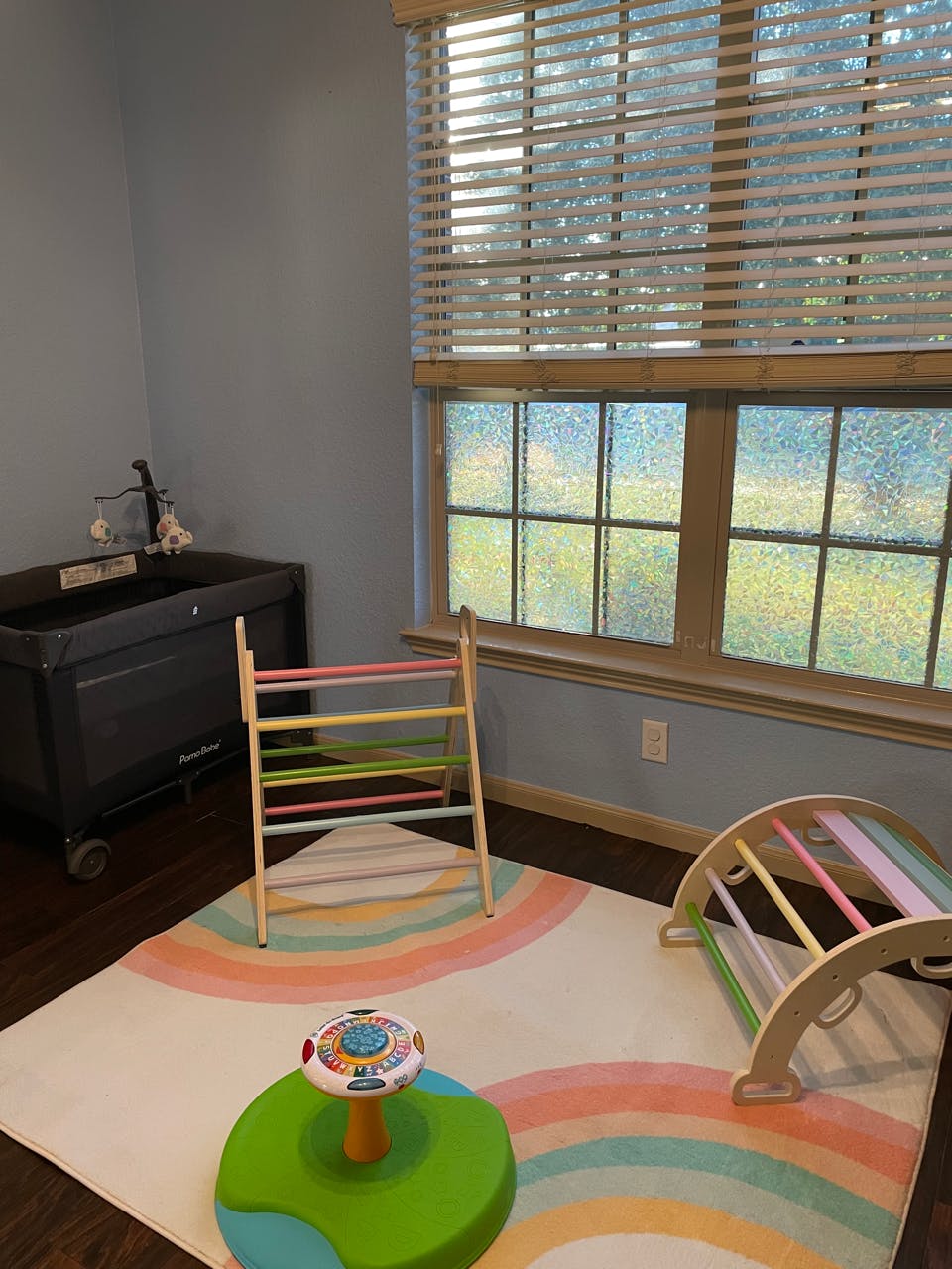 Children's play area with a climbing ladder, arch, and rainbow rug