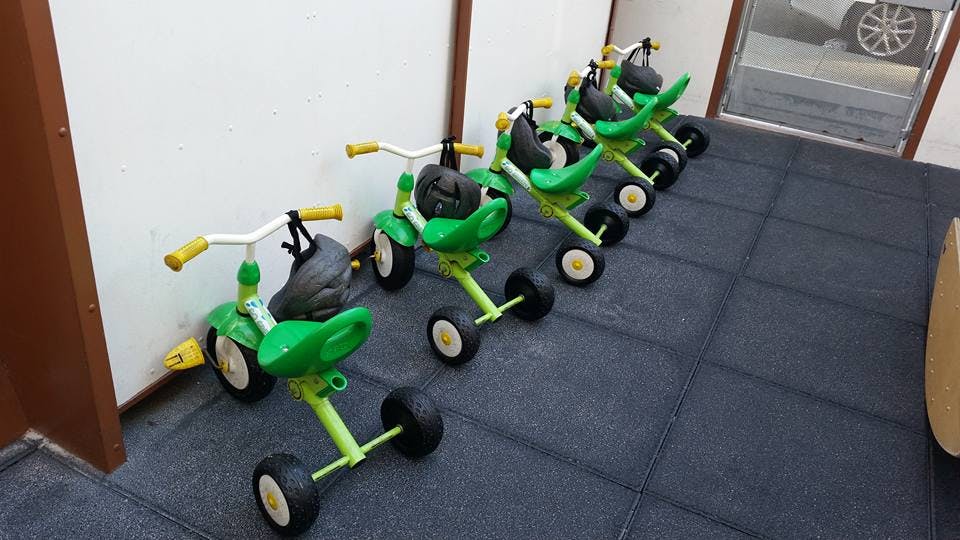 Row of green and yellow tricycles