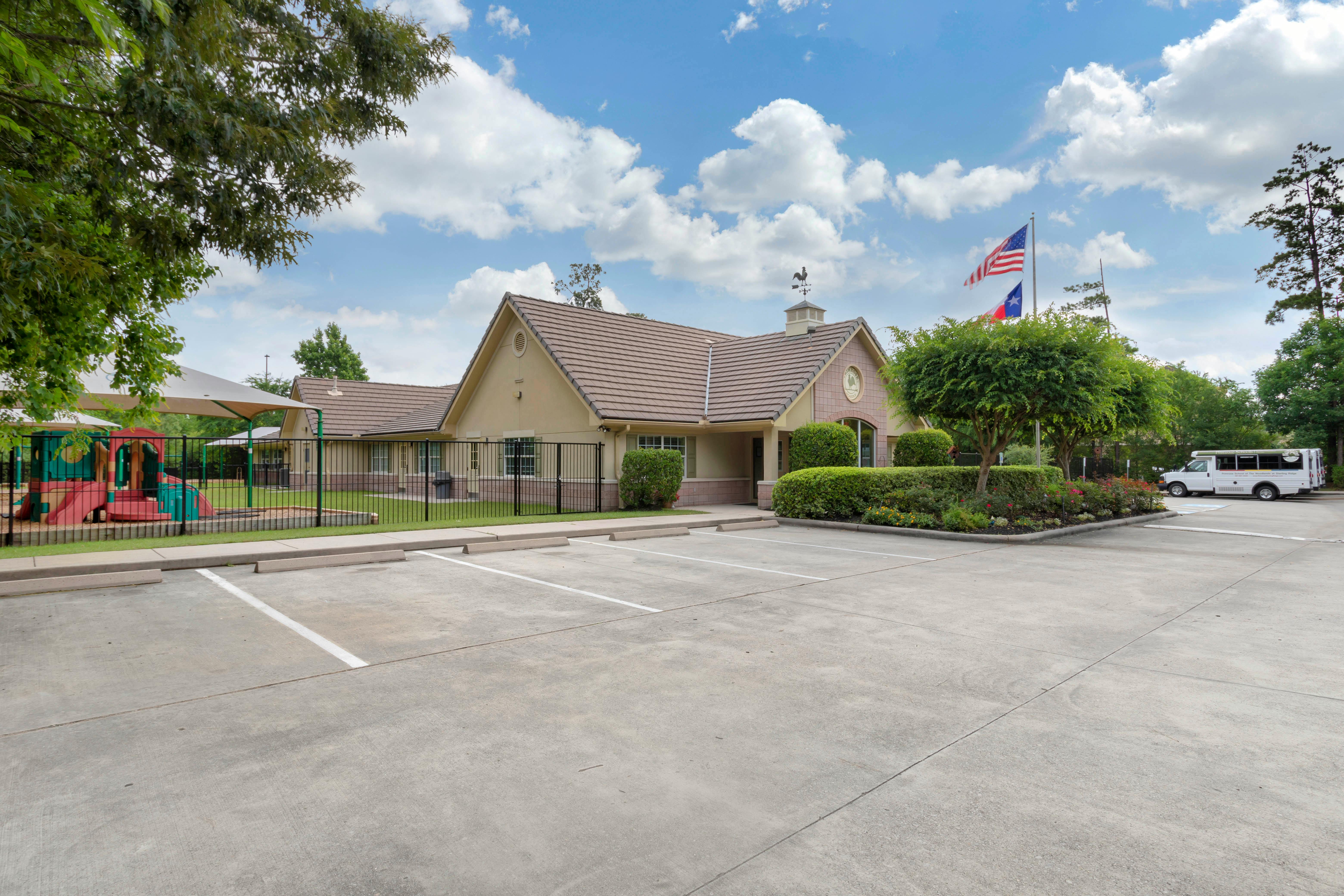 A low-slung building with a playground and empty parking lot