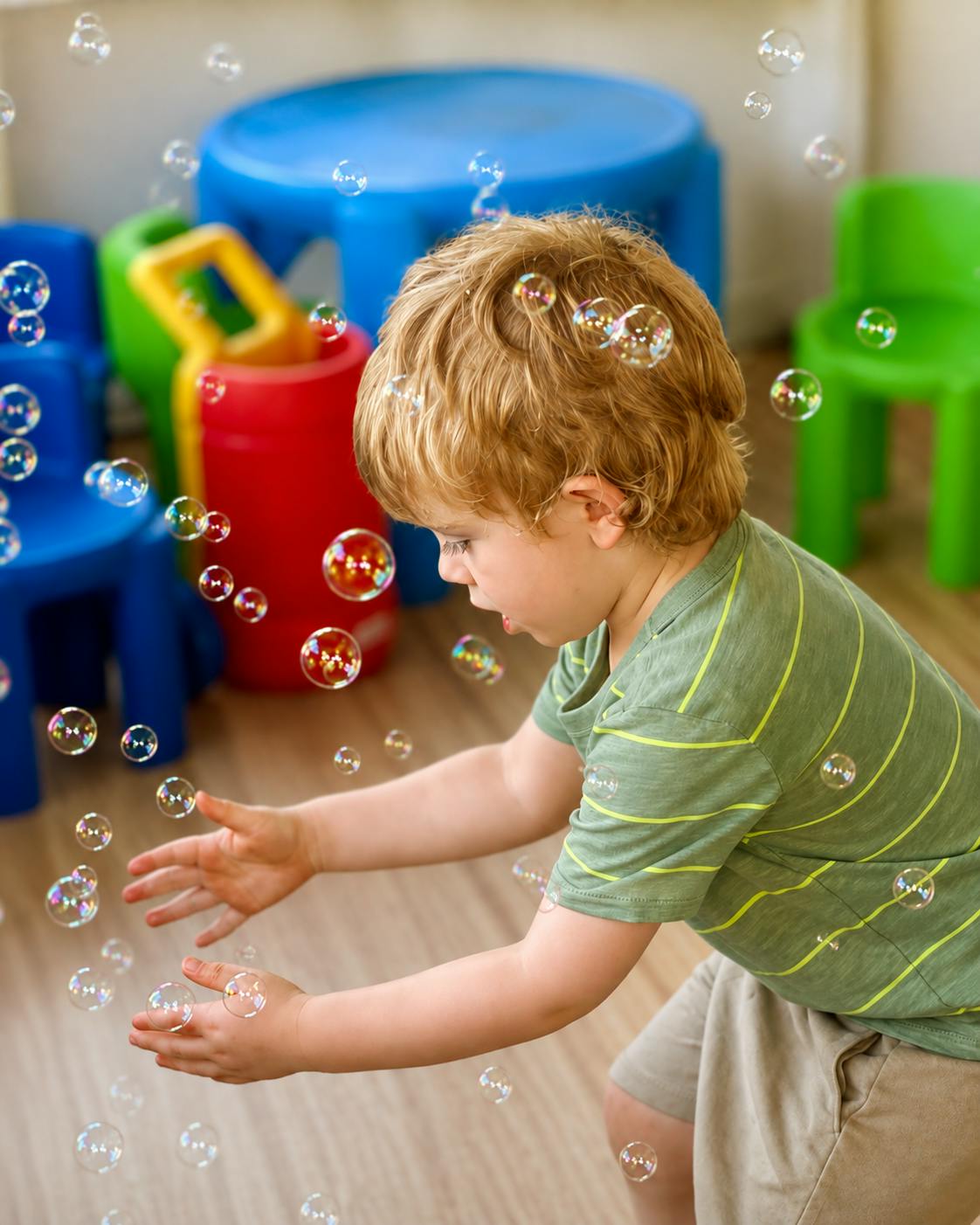 Child reaching for floating bubbles in a playroom