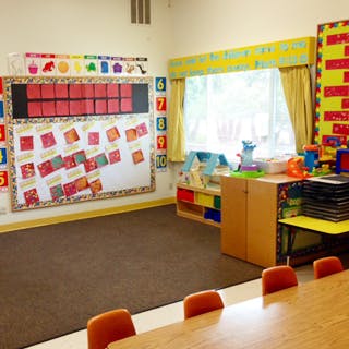 Empty classroom with bulletin boards and a table with chairs