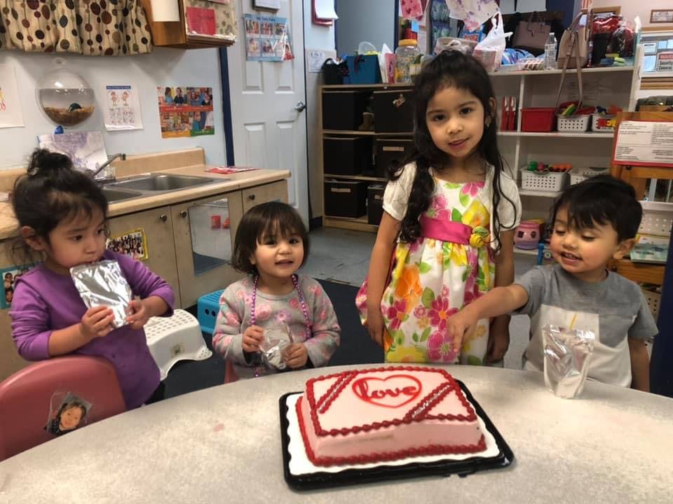 Four children around a table with a cake decorated cake