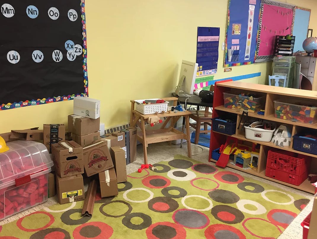 Classroom with a colorful rug, shelves, and boxes