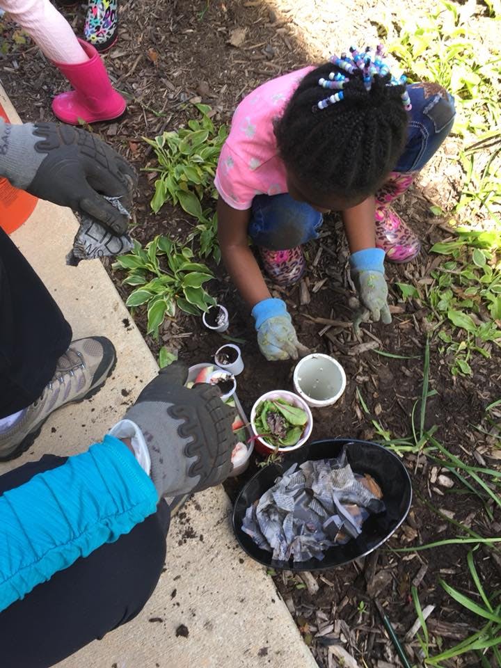Child and person gardening, planting small plants in dirt