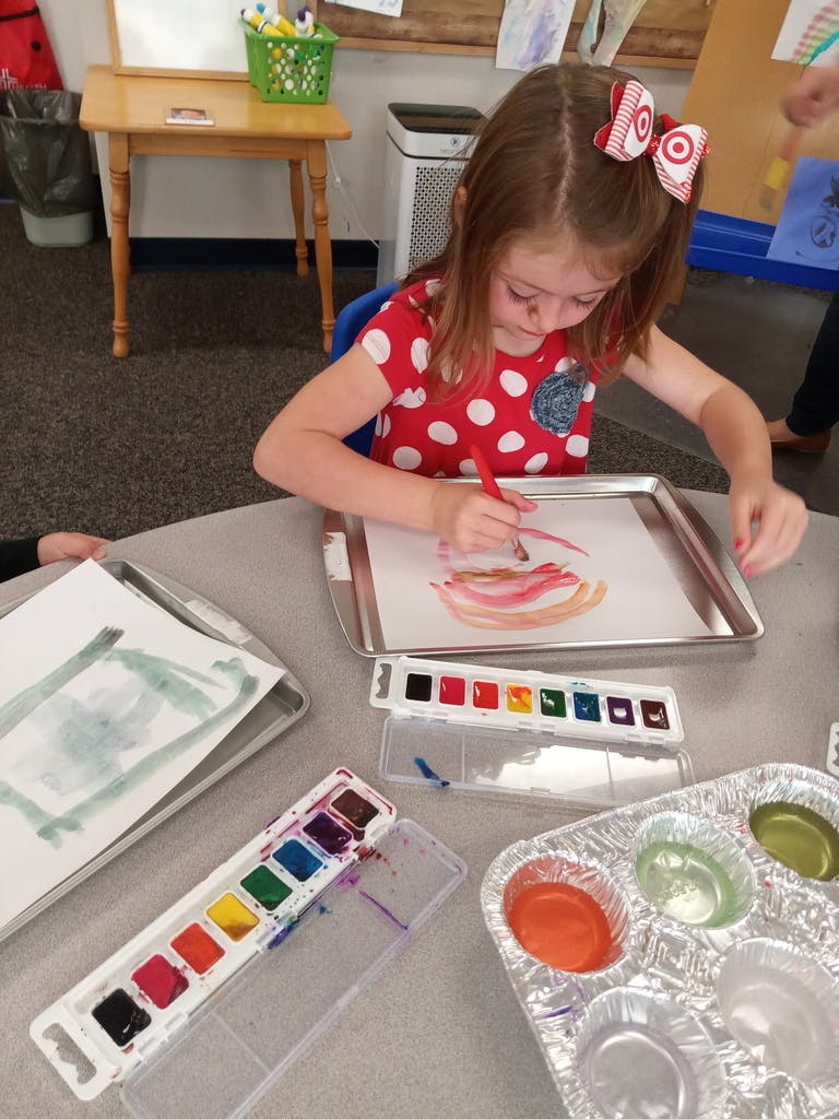 Child painting with watercolors at a table