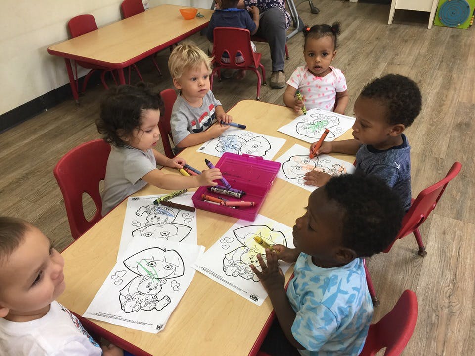 Children coloring at a table in a classroom