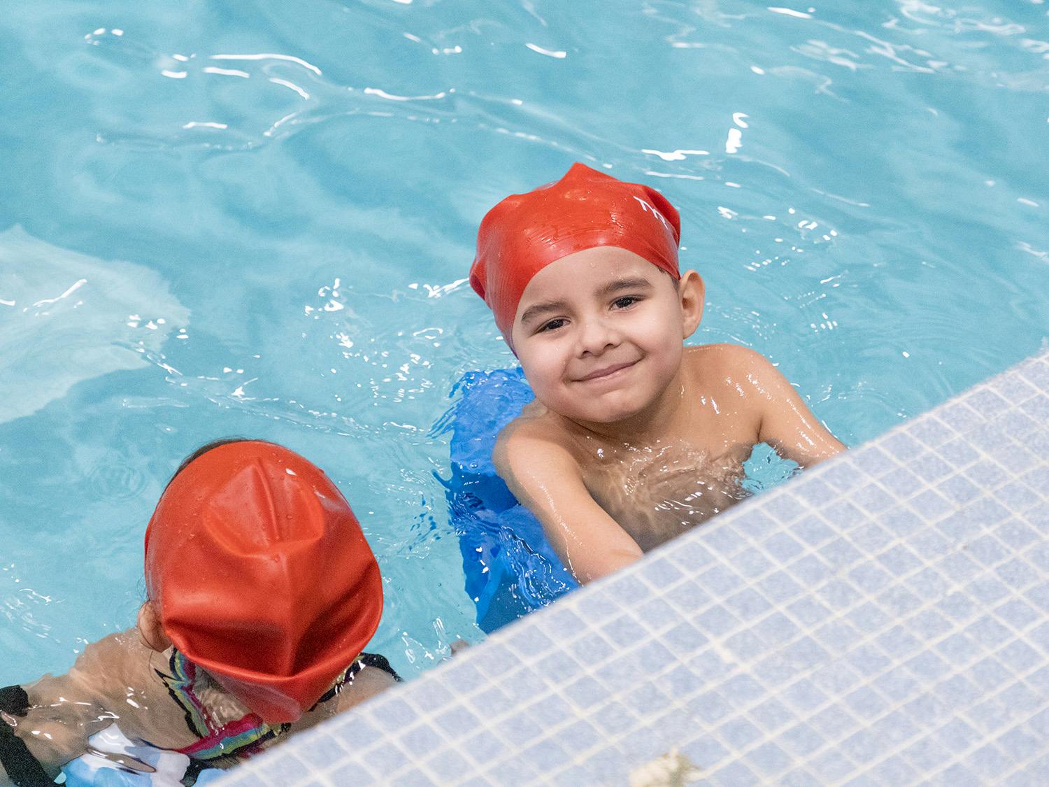 Child in a red swim cap in a pool