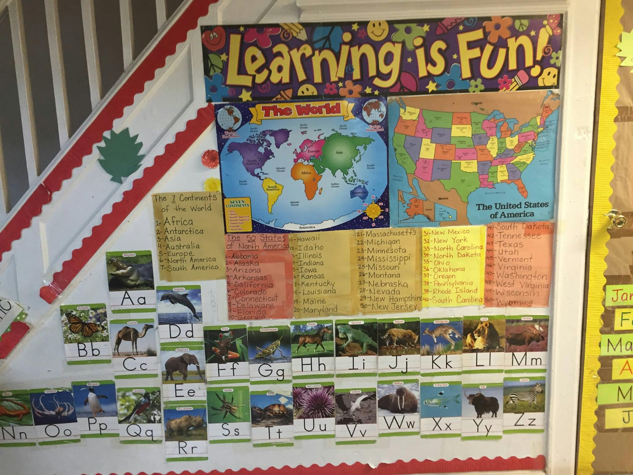 Classroom wall with world map, US map, and alphabet animal cards