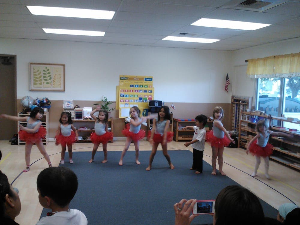 Children in red tutus dancing in a room