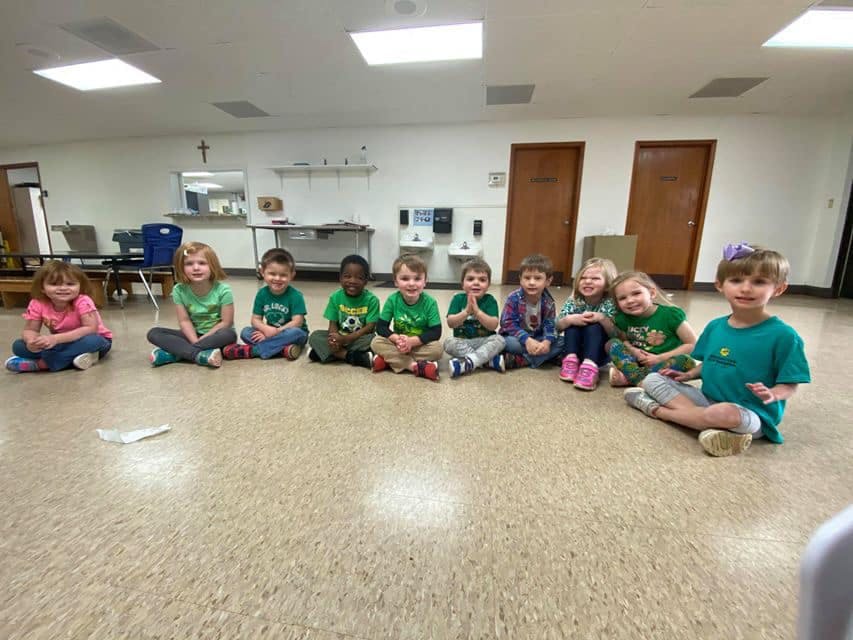 Group of children sitting on the floor in a classroom