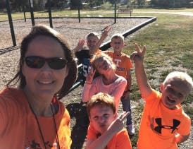 Adult and five children posing for a photo outdoors