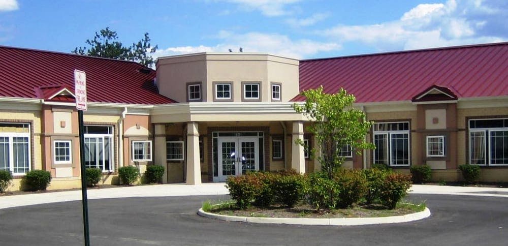 Building with a red roof and a circular driveway