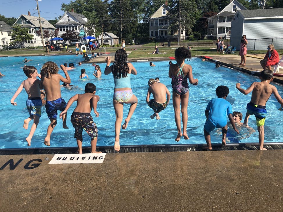 Children jumping into a swimming pool