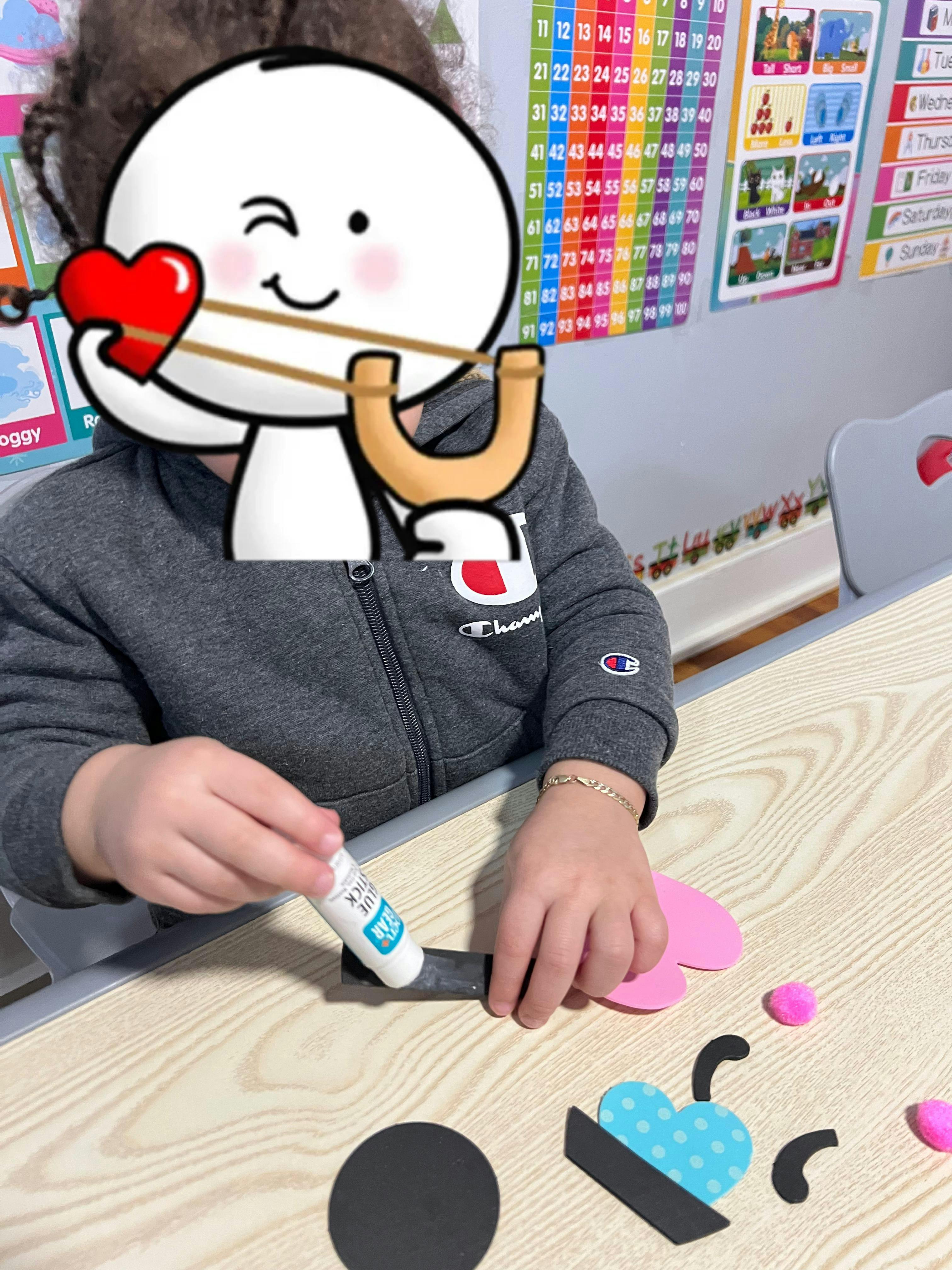 Child gluing craft pieces in a classroom