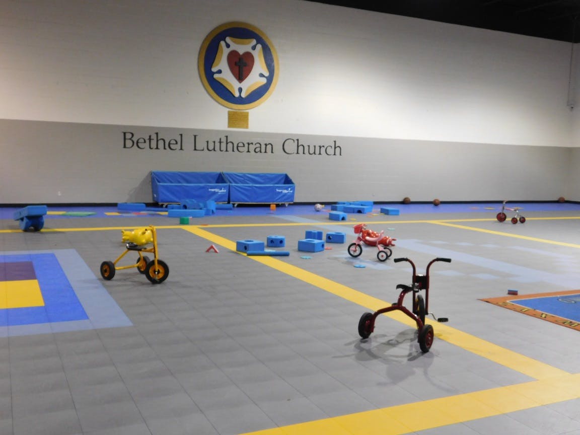 Indoor play area with tricycles and blue blocks