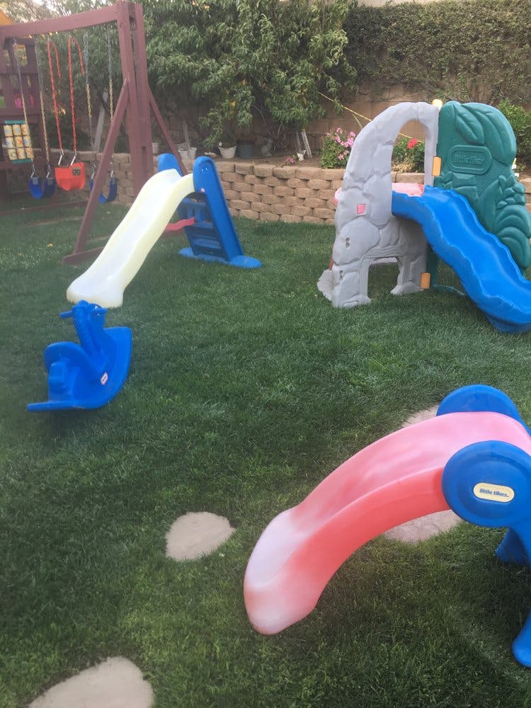 Playground with multiple slides and a swing set on grass