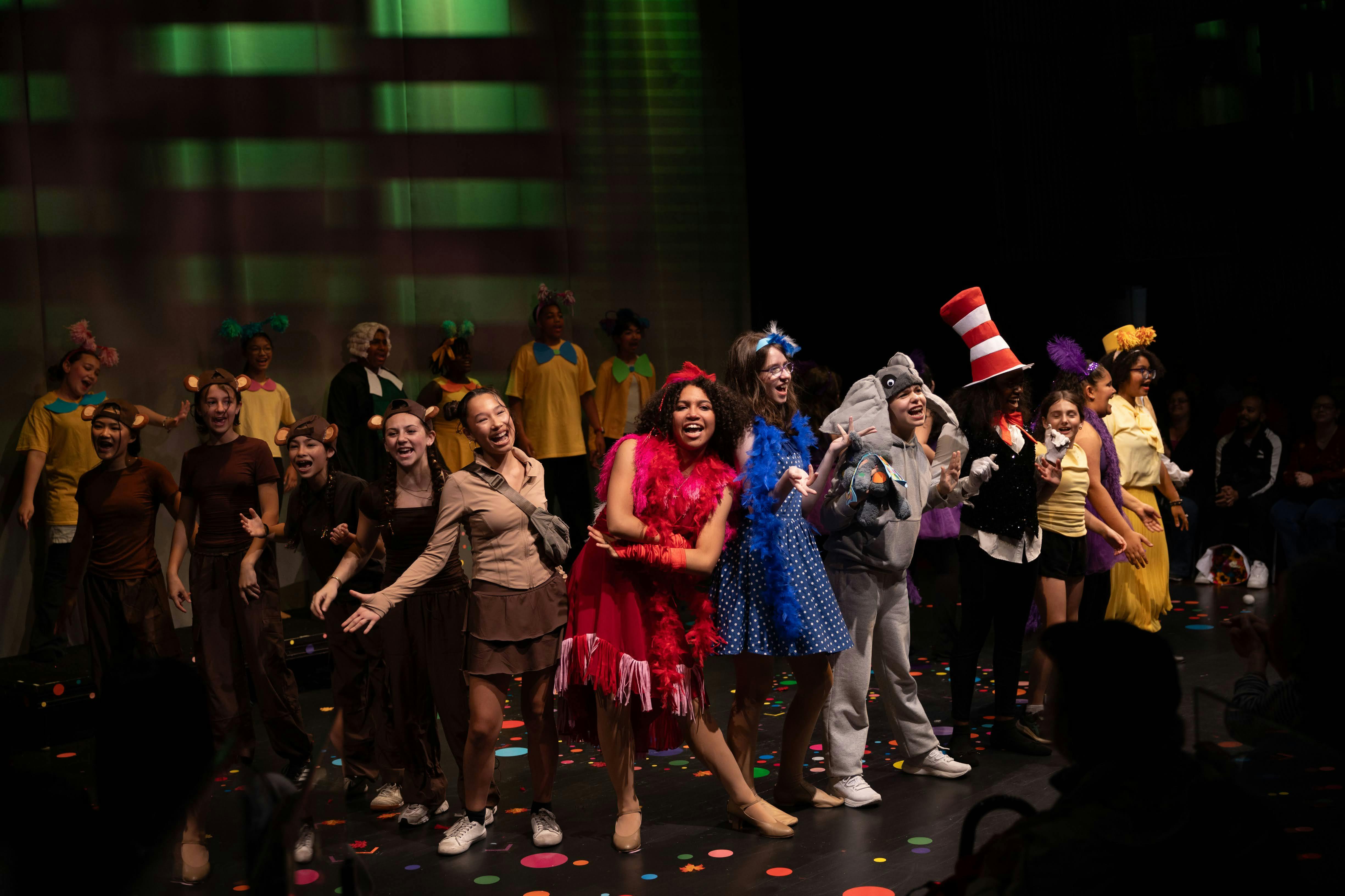 Group of teens in costumes performing on a stage