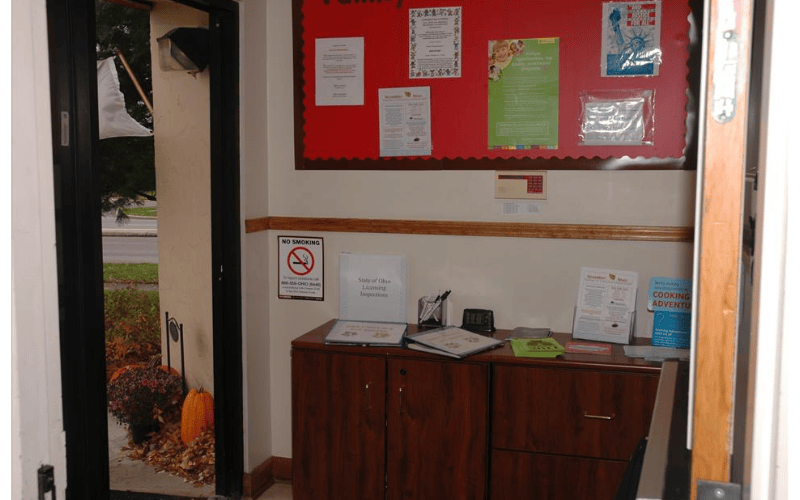 Entrance to a building with a bulletin board and wooden cabinet