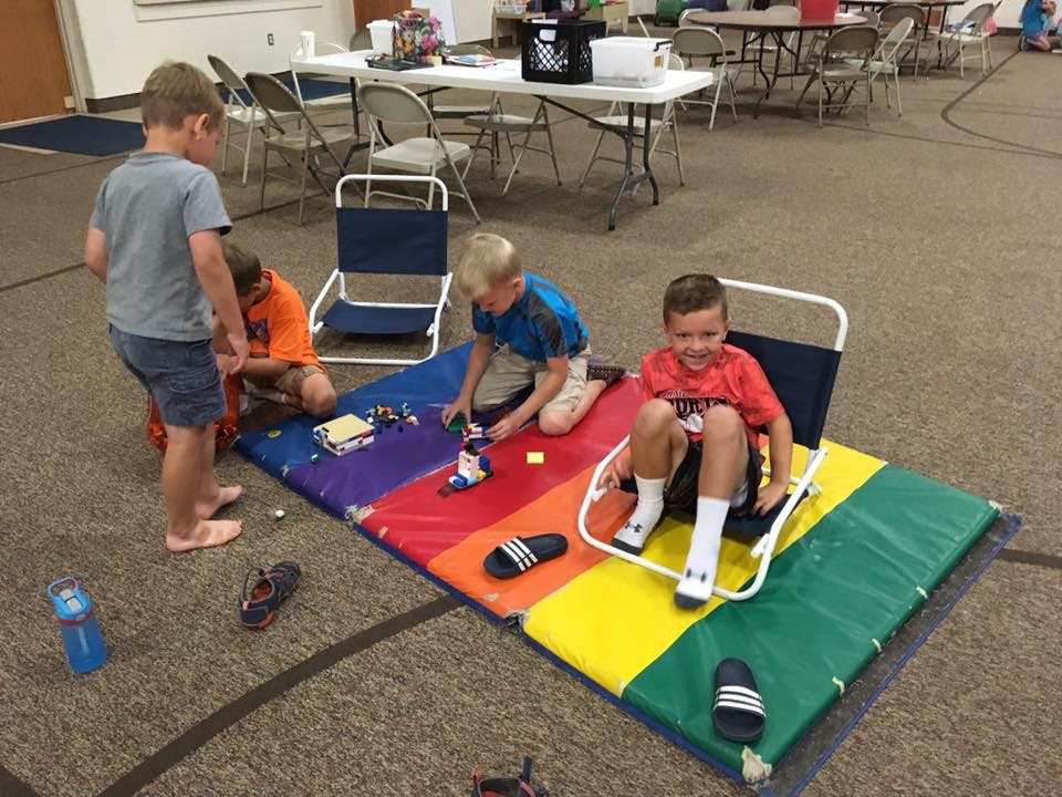 Children playing with toys on a colorful mat
