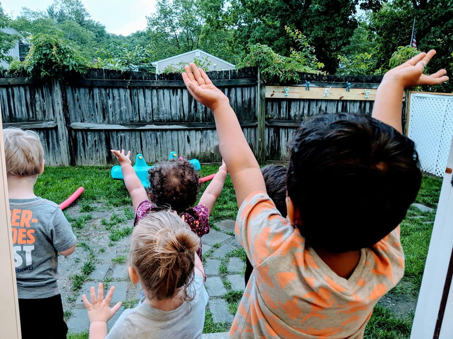 Children with arms raised outdoors