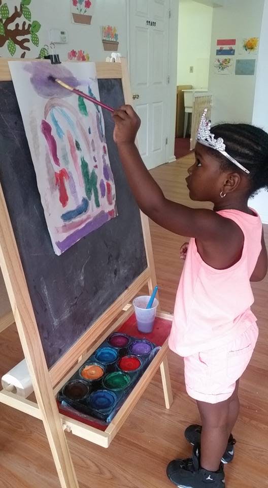 Child painting on an easel with watercolors