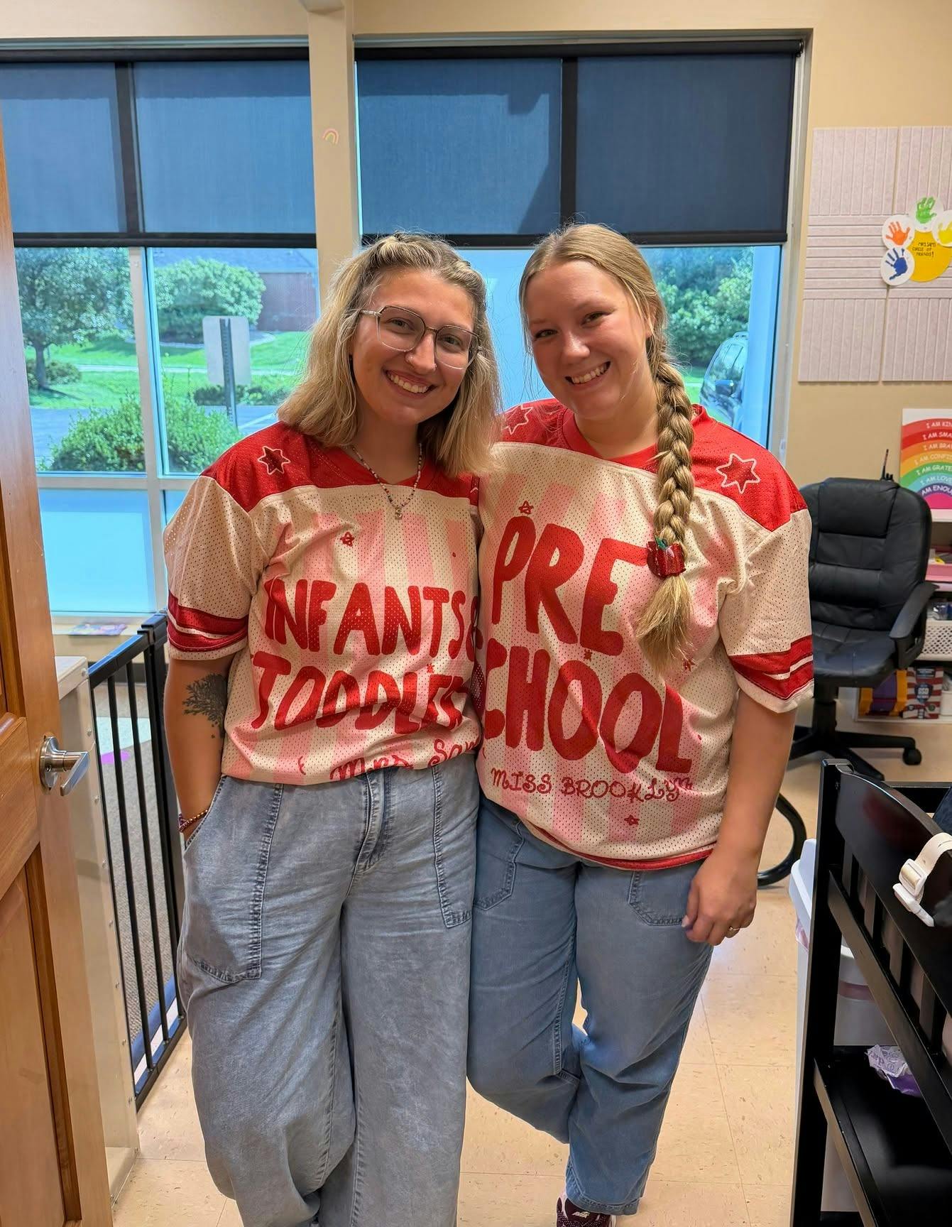 Two people wearing shirts labeled Infants Toddlers and Preschool