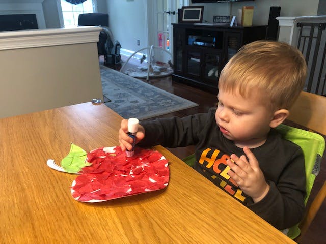 Child making a craft at a table