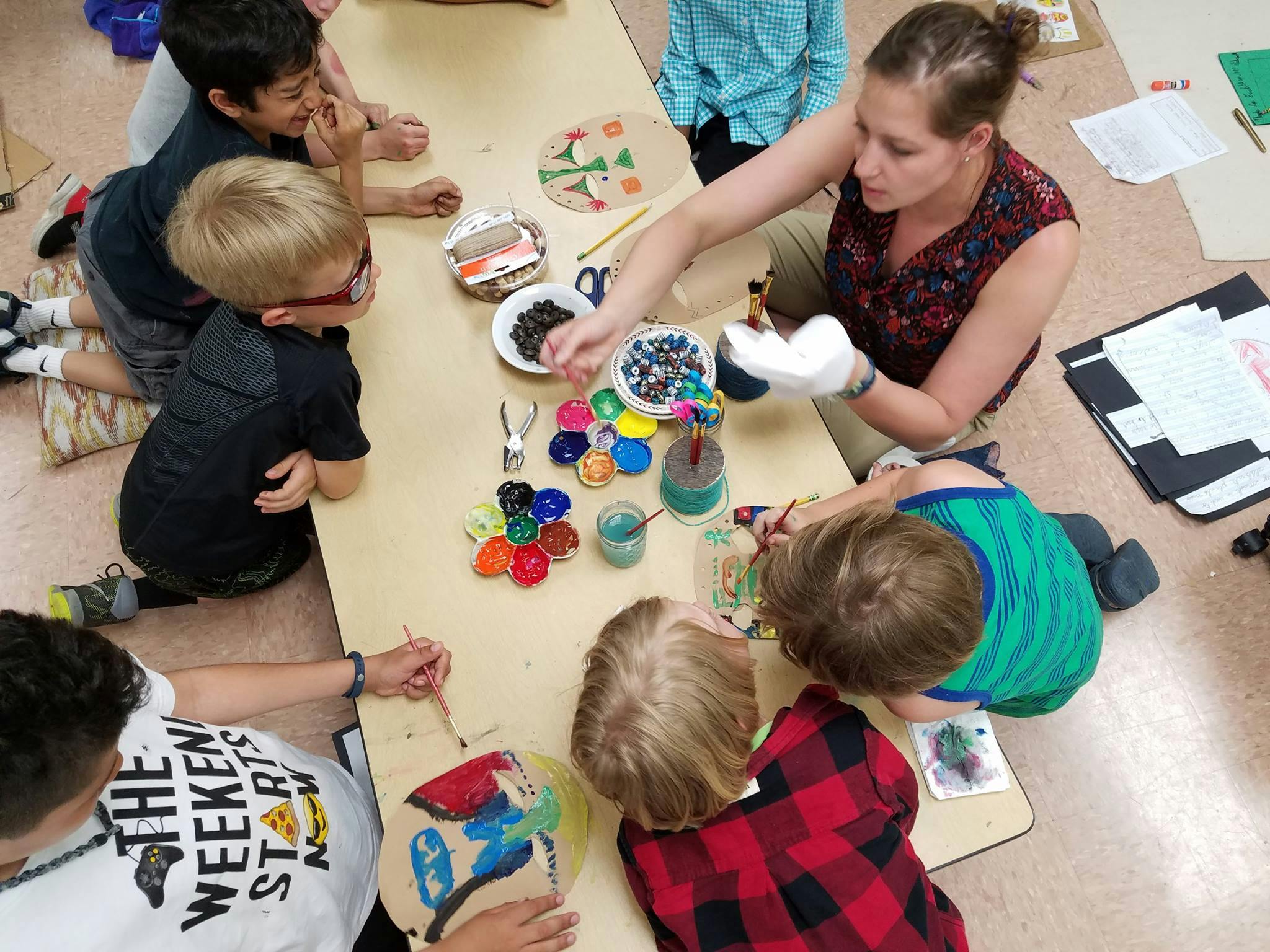 Adult and children doing crafts at a table