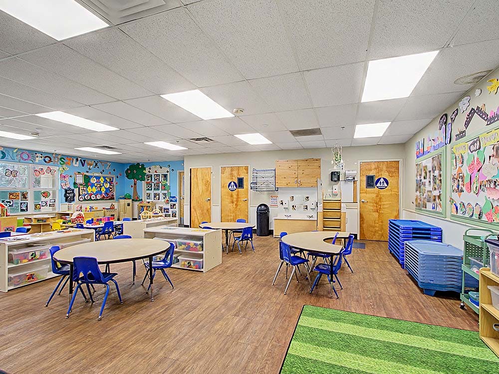 Empty classroom with small tables and chairs, decorated walls