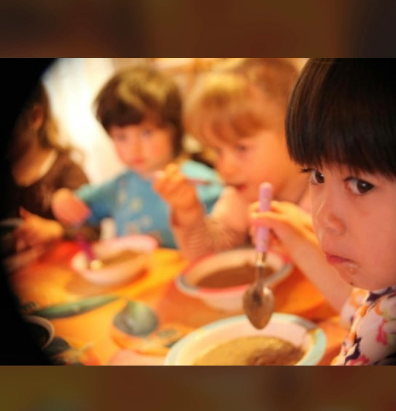 Children eating from bowls with spoons
