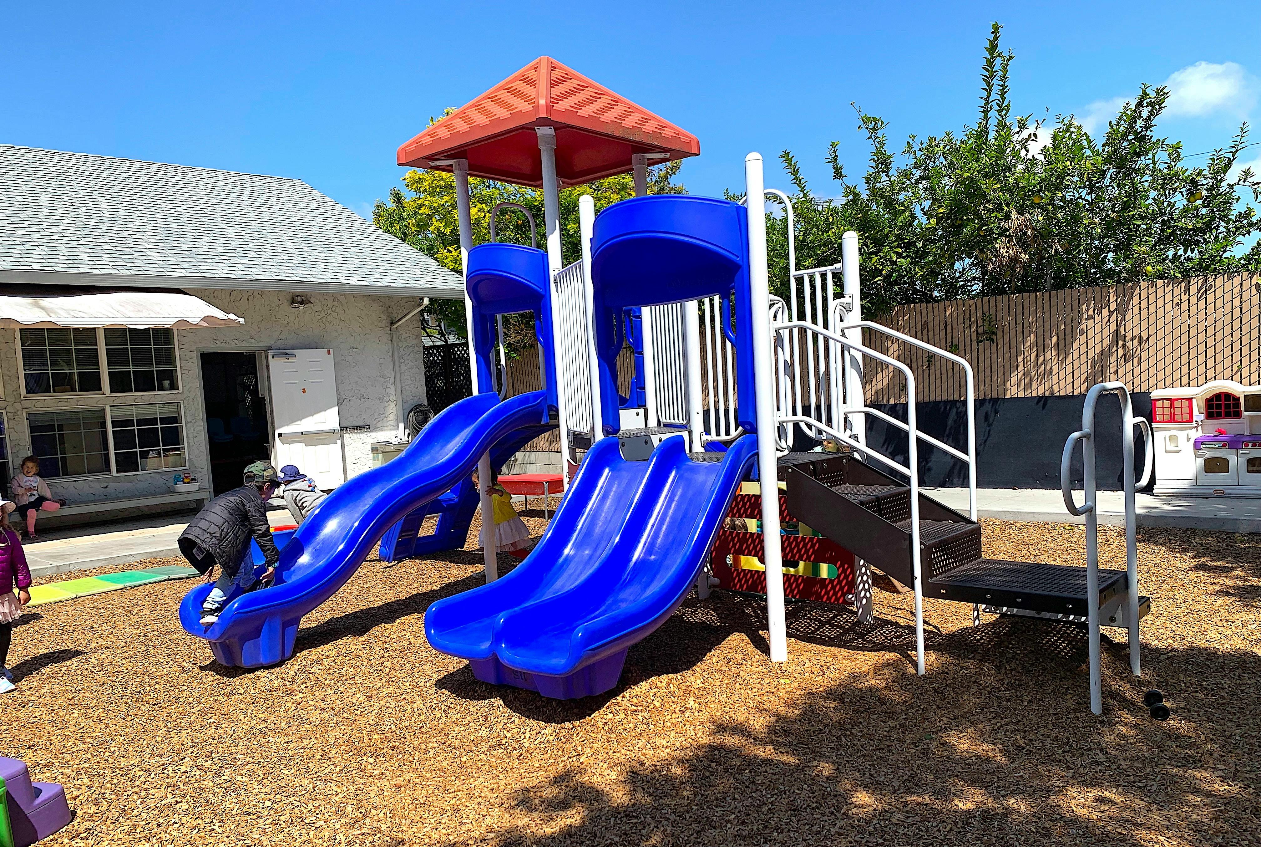 Child on a blue playground slide