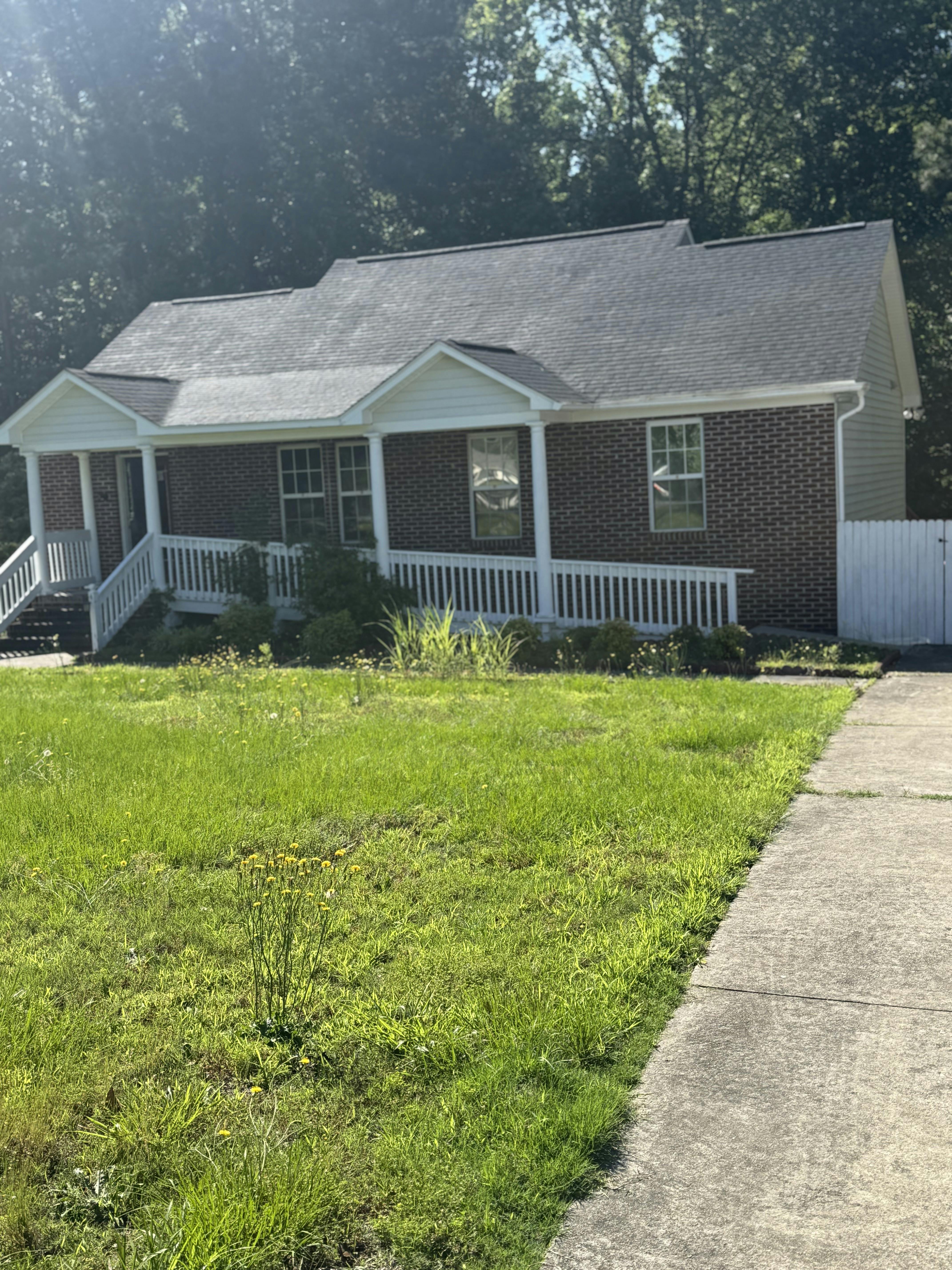 Brick house with white porch railing and green lawn