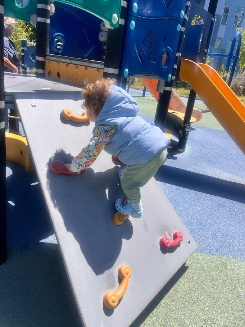 Child climbing a rock wall on a playground