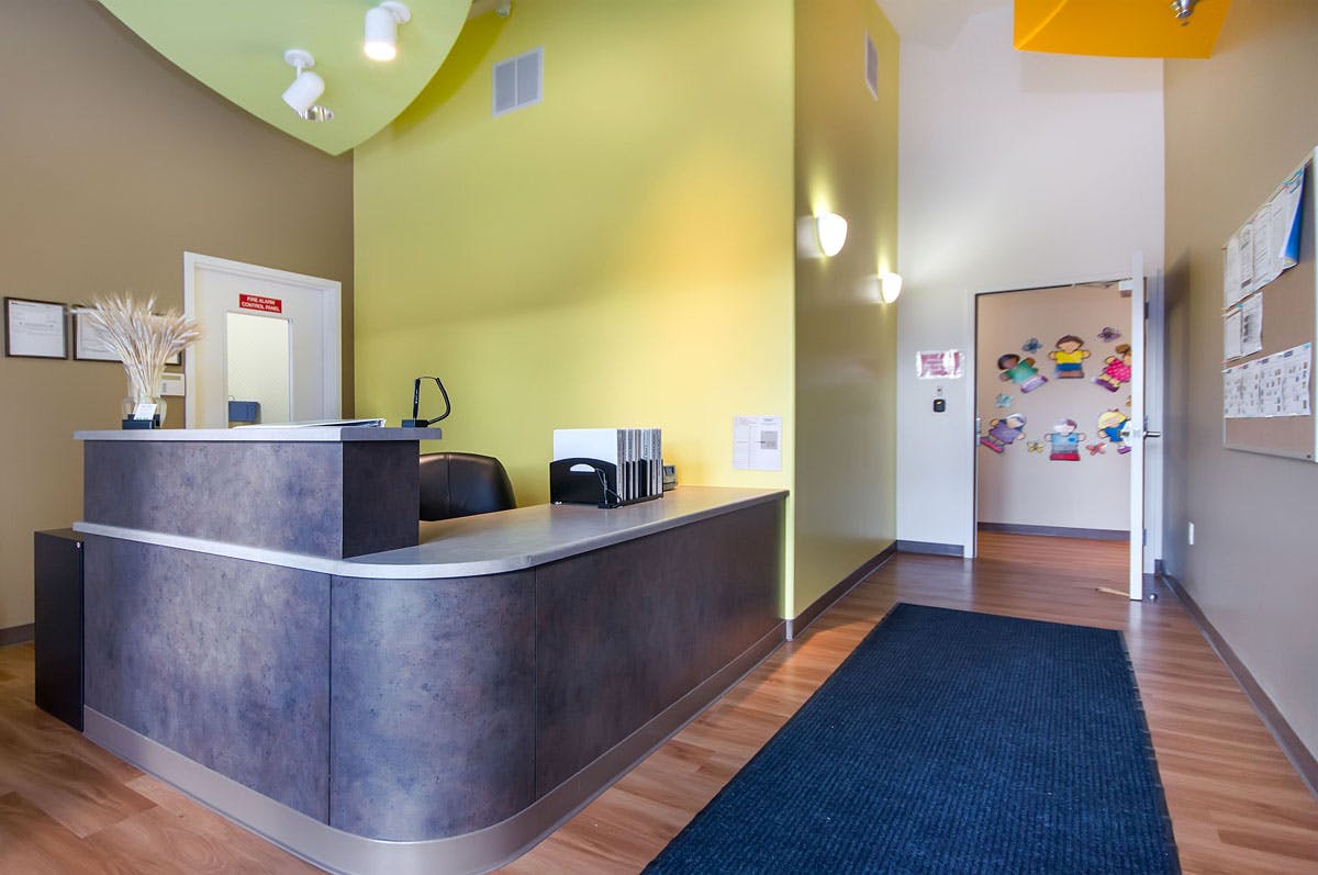 Reception desk in a brightly lit room with a blue rug