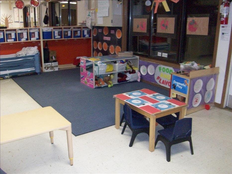Classroom with small tables, chairs, and cubbies