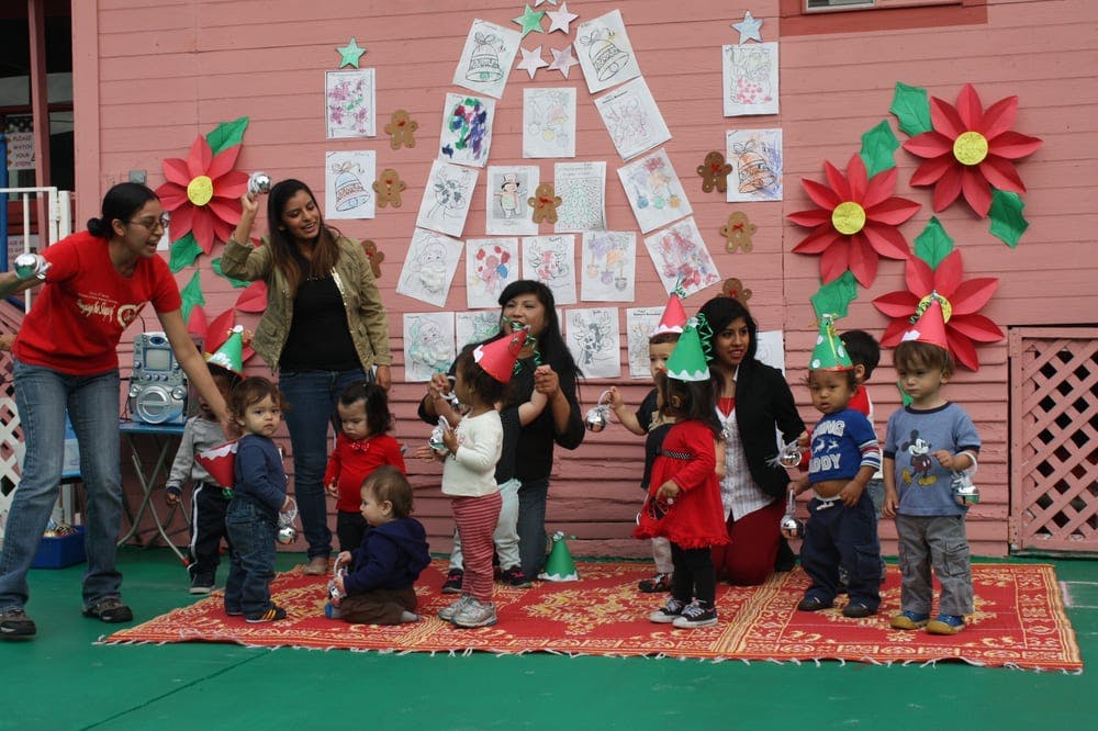 Adults and children in party hats standing on a rug