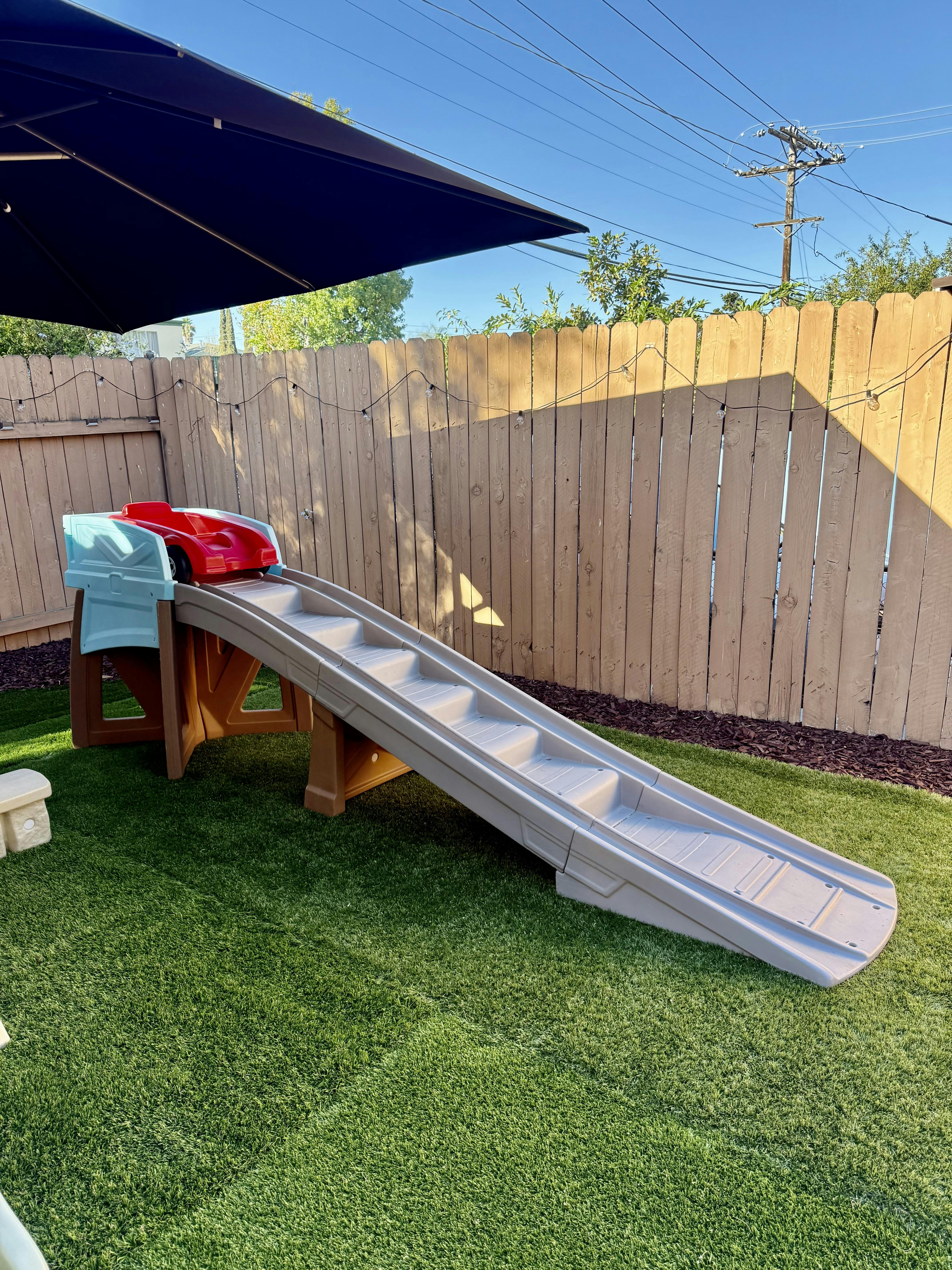 Toy car on a plastic ramp in a backyard