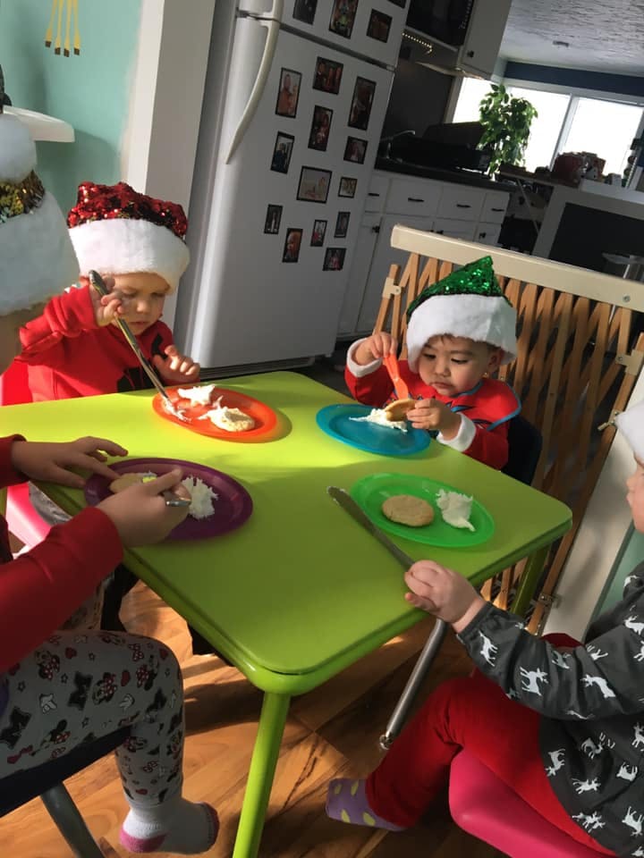 Children in Santa hats eating at a table