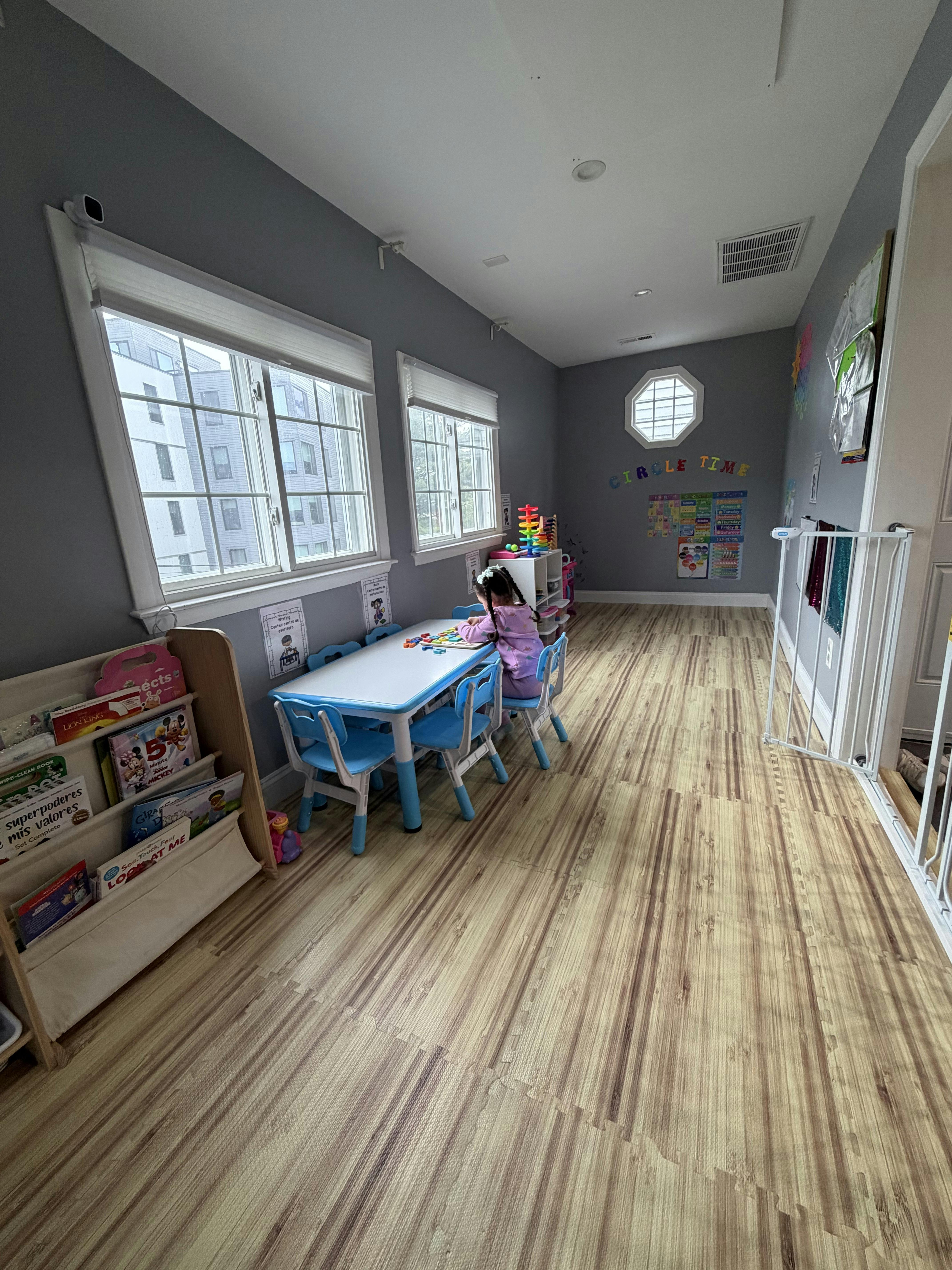 Child playing with a puzzle at a small table in a bright room