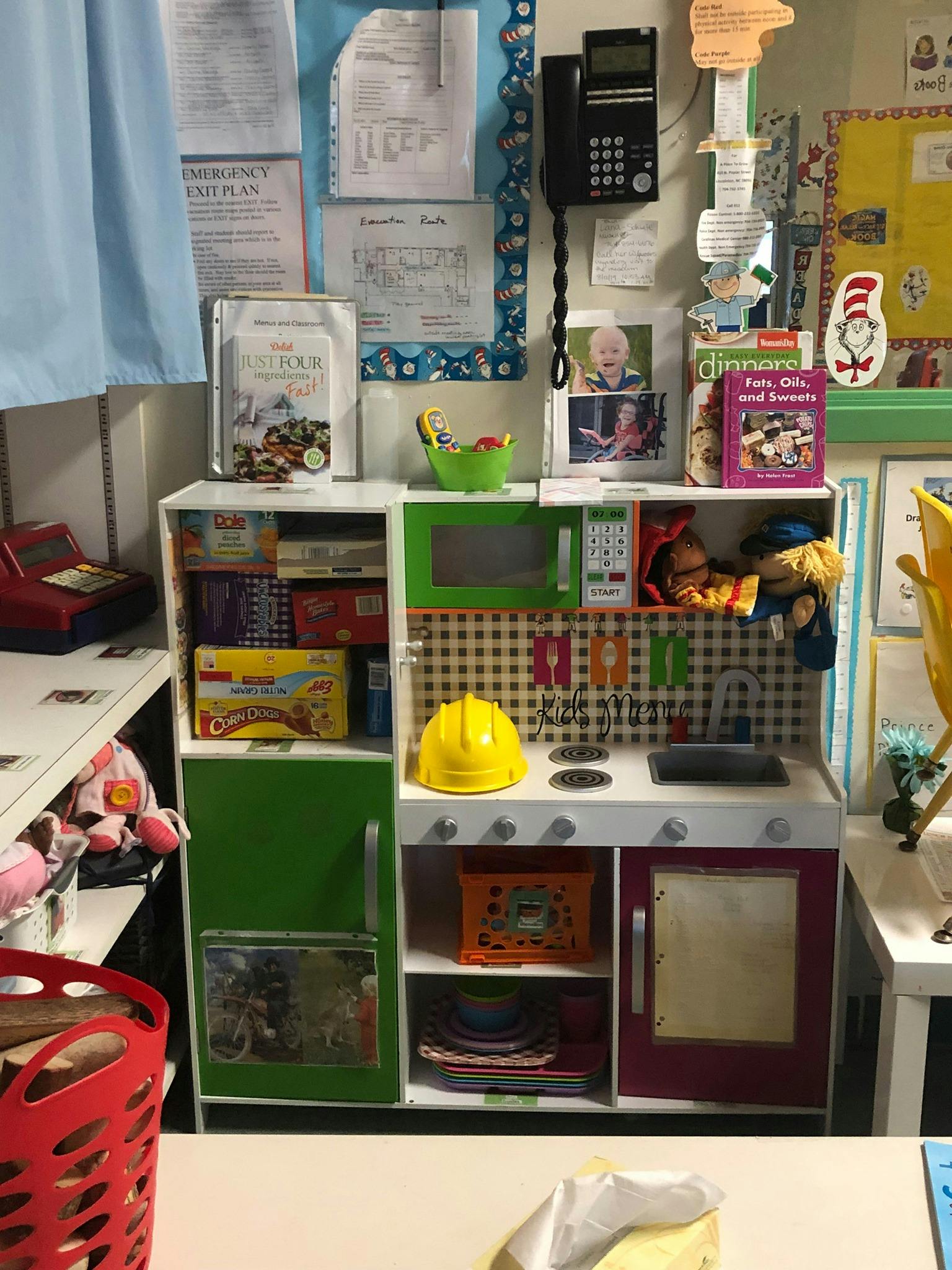 Child's play kitchen with a yellow hard hat on the stove