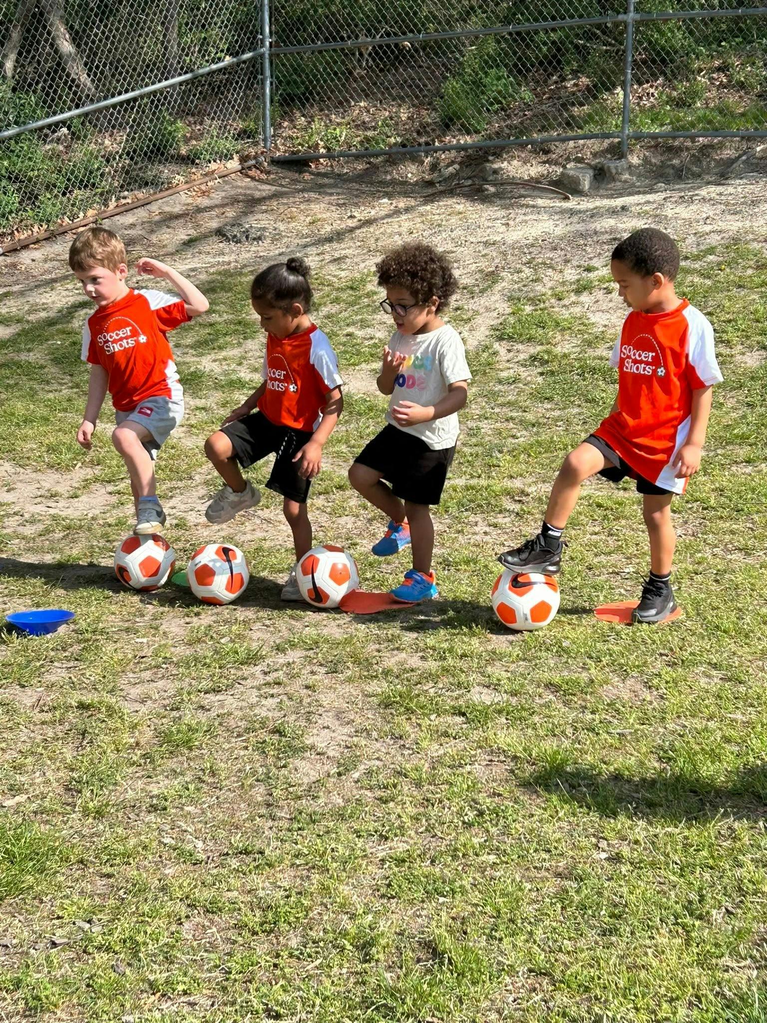 Children practicing soccer drills on a grassy field