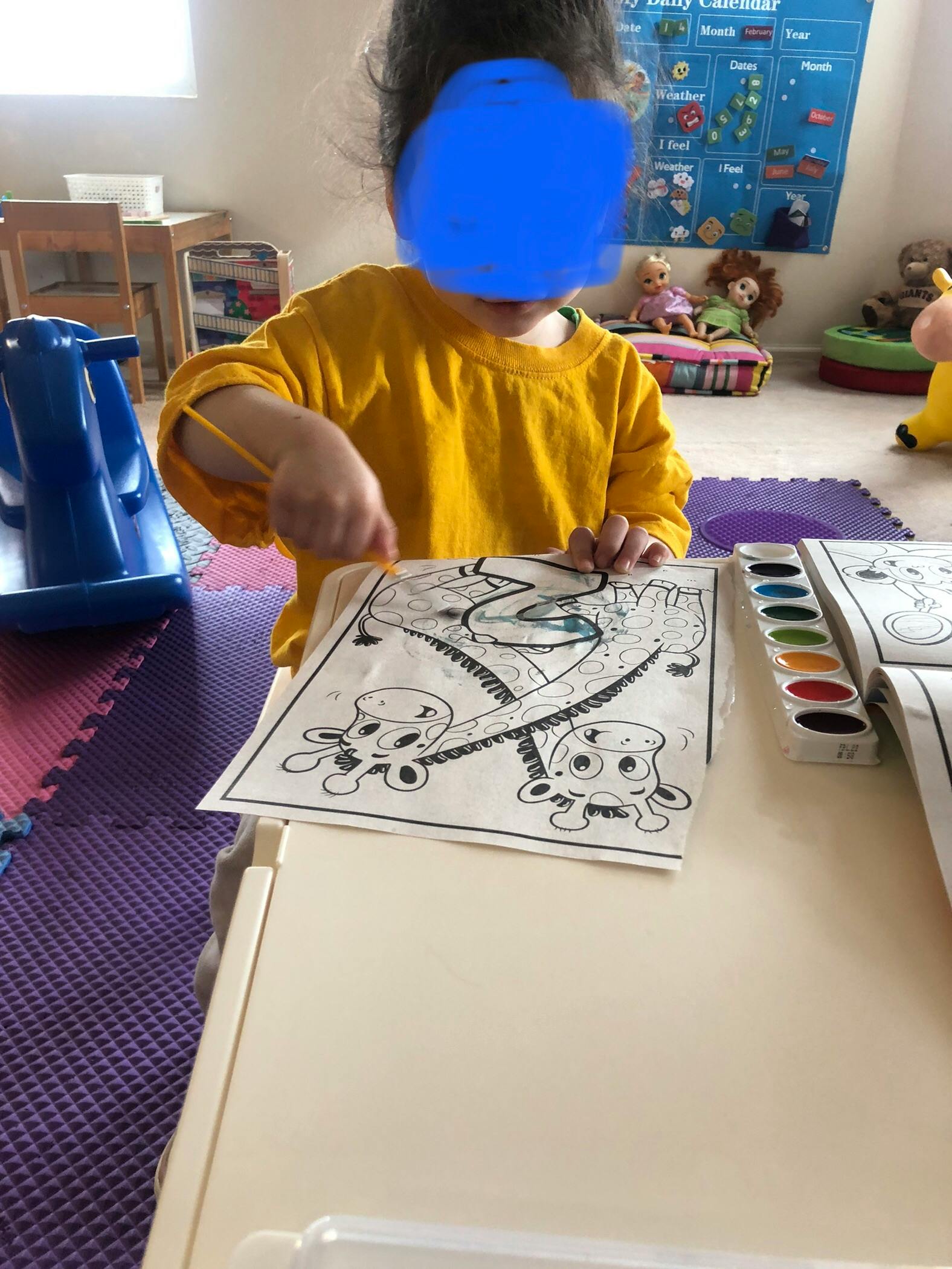 Child coloring a picture with watercolors