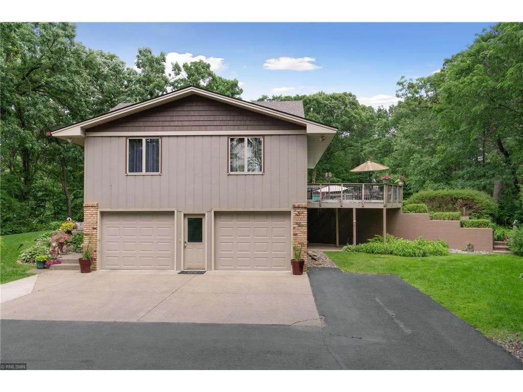 Split-level house with two garage doors and an elevated deck