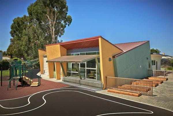 Modern building with playground and paved area