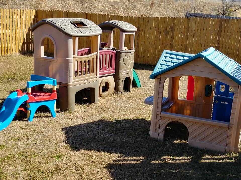 Outdoor playground with two playhouses and a slide