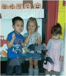 Three children holding bat cutouts