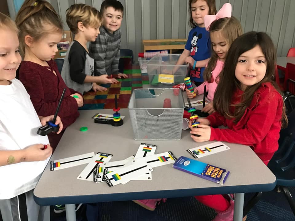 Children playing with coding robots and cards at a table