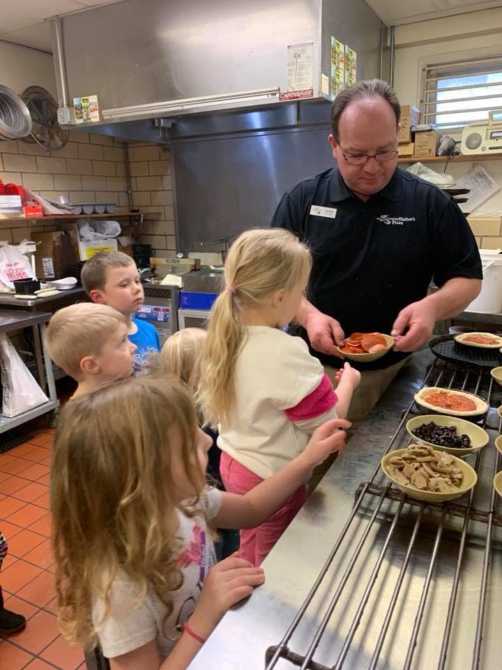Adult and children preparing food in a kitchen