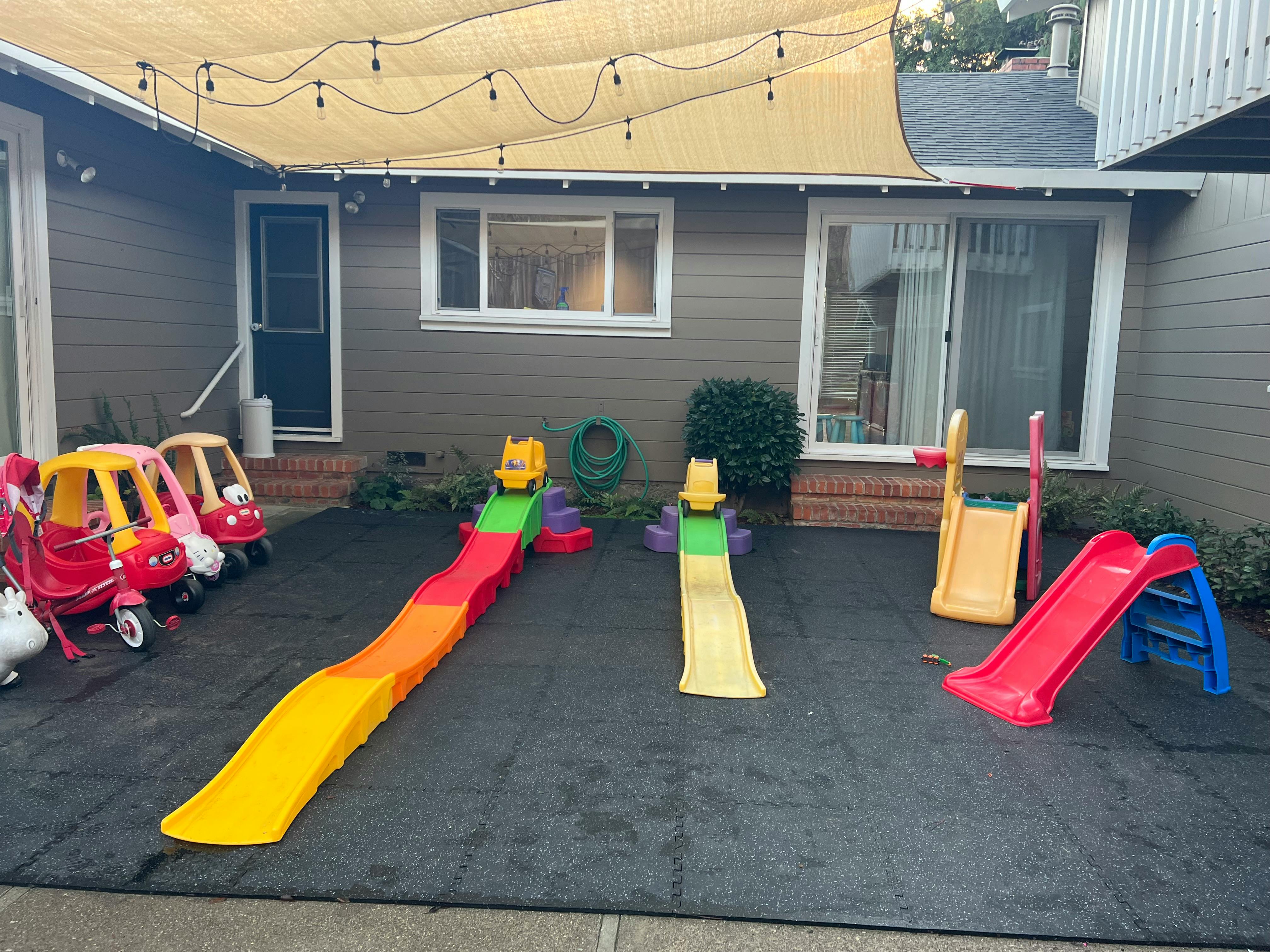 Outdoor play area with multiple slides and toy cars