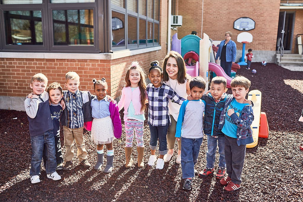 Adult and group of children standing outdoors
